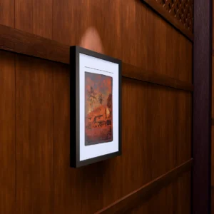 Frame 526 in Sunset - Wall Frame 526 in Sunset, gel plate monotype by Daniel Arendzen, framed on a wooden wall under a spotlight, seen from the side, with binoculars, a watch and a lighter on a table below. The room is a Blender render of the interior of the same traditional Malaysian house shown in the print.