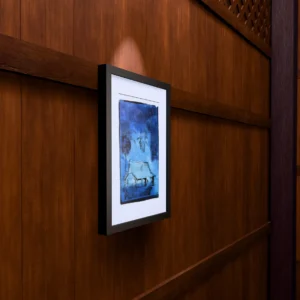 Frame 532 #3 Study, gel plate monotype by Daniel Arendzen, framed on a wooden wall under a spotlight, seen from the side, with binoculars, a watch and a lighter on a table below. The room is a Blender render of the interior of the same traditional Malaysian house shown in the print.