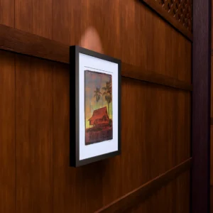 Purple Lake, gel plate monotype by Daniel Arendzen, framed on a wooden wall under a spotlight, seen from the side, with binoculars, a watch and a lighter on a table below. The room is a Blender render of the interior of the same traditional Malaysian house shown in the print.